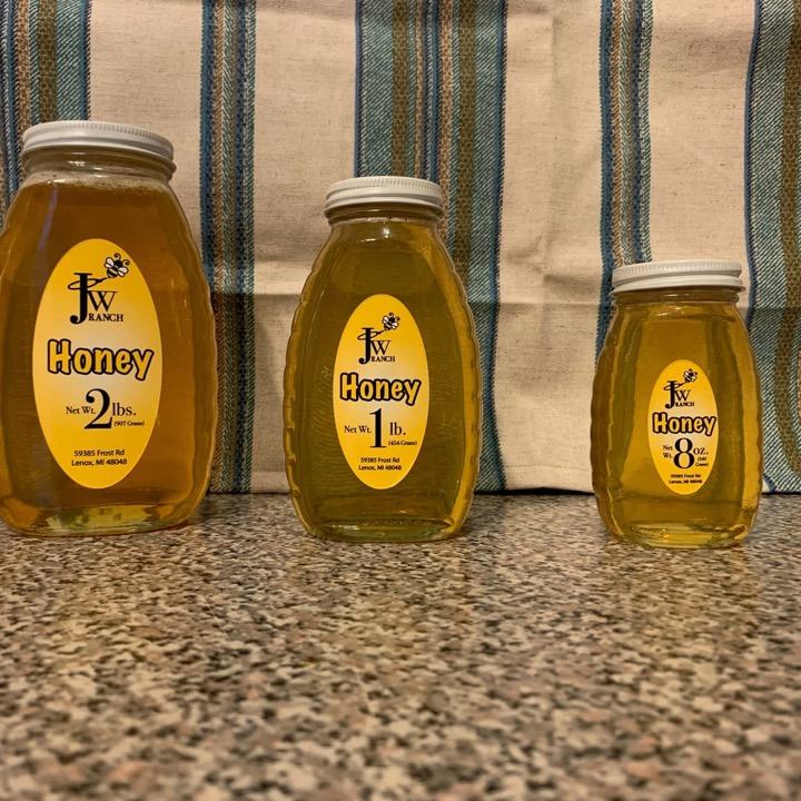 Three sizes of honey jars with oval JW Ranch labels