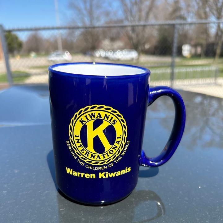 A blue mug printed with the gold Kiwanis International seal and Warren Kiwanis