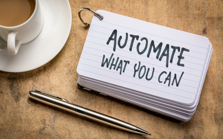 A handwritten note reading "Automate what you can" beside a cup of coffee
