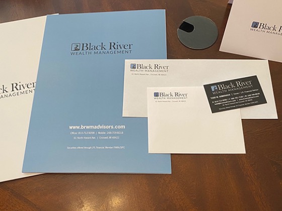Black River Wealth Management folder, letterhead, envelopes and business cards laid out on a table