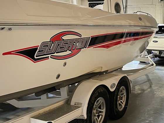 Sunsation powerboat hull with red and black swoosh graphics on the factory floor