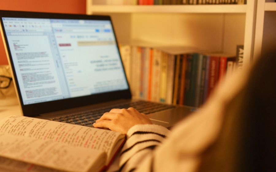 Notes and a laptop open on a desk, the plan being read
