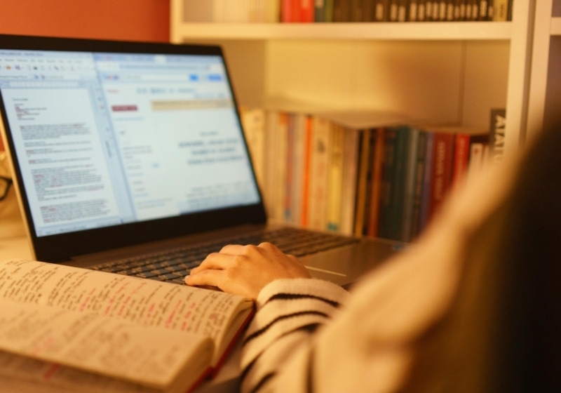A laptop and handwritten notes on a desk